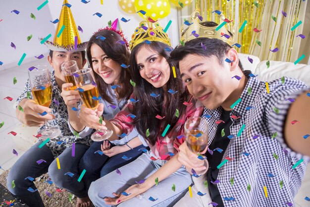 Des jeunes heureux se font un selfie à une fête d'anniversaire.