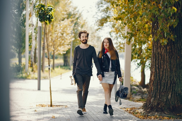 jeunes hipsters debout dans un parc ensoleillé d&#39;été avec une planche à roulettes dans leurs mains