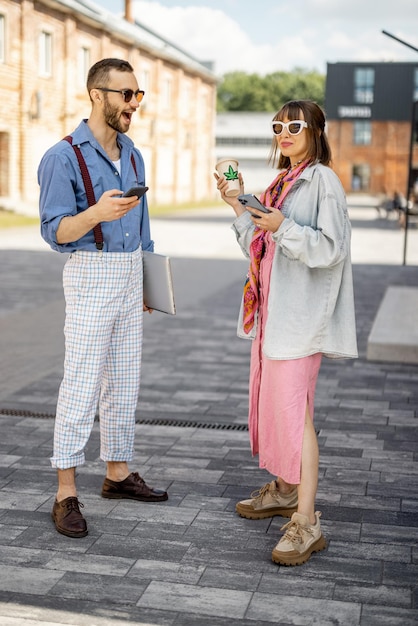 Les jeunes hipsters traînent ensemble près du bureau à l'extérieur