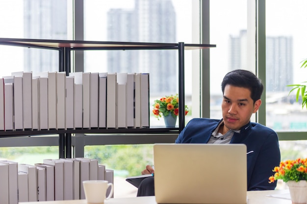 Jeunes hommes d'affaires asiatiques regardant le carnet de rendez-vous au bureau