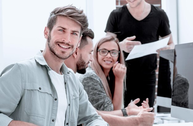 Les jeunes hommes d'affaires au bureau travaillent avec un ordinateur