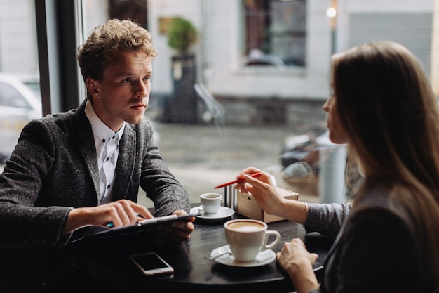 Jeunes hommes d'affaires ayant une réunion dans un café