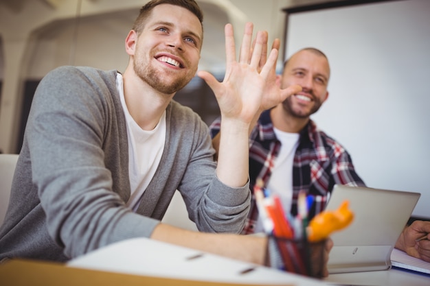 Jeunes hommes d'affaires gesticulant au bureau dans le bureau créatif