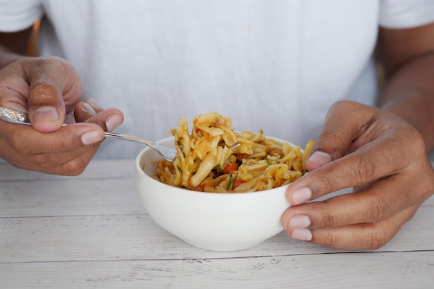 Jeunes hommes mangeant des pâtes sur la table