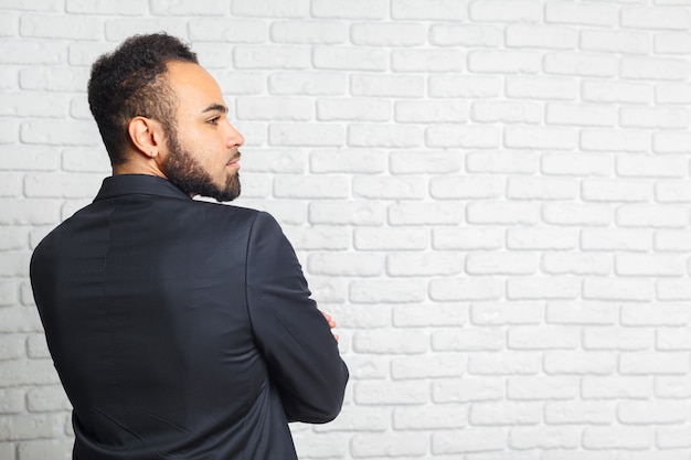 Jeunes Hommes à La Mode Dans Un Costume Contre Le Mur De Briques