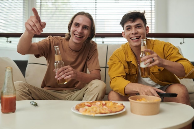 Jeunes hommes regardant un match à la maison