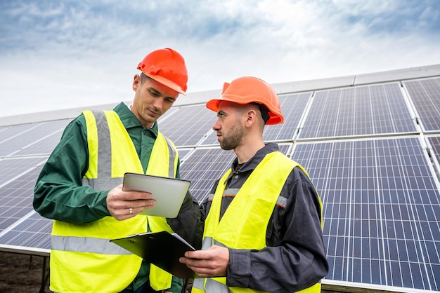 De jeunes hommes robustes en salopette sont arrivés pour discuter d'un plan d'installation de panneaux solaires