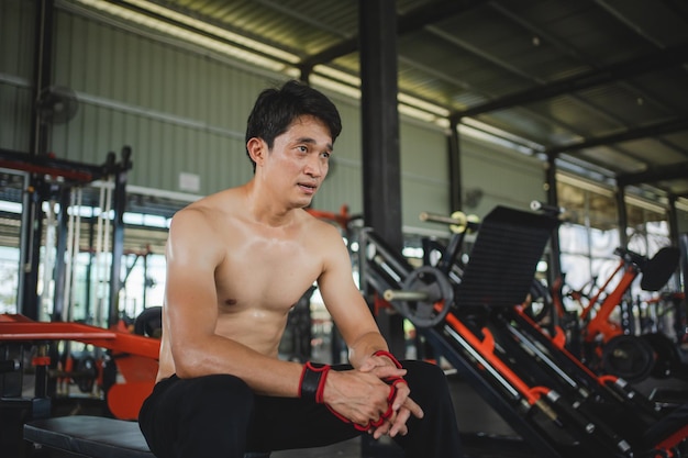 Photo jeunes hommes se reposant après un entraînement intensif au gymnase homme en bonne santé fatigué après un entraînement de force au gymnase