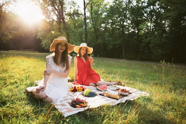 Jeunes jolies filles sur un pique-nique dans un parc de la ville.