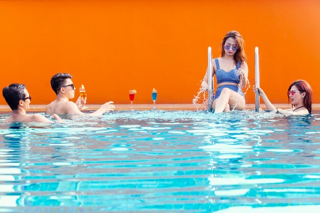 Jeunes en maillot de bain jouant de l'eau sur la piscine