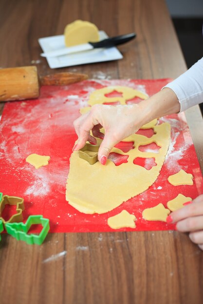 Les jeunes mains coupant la pâte de gingembre à la cuisine moderne