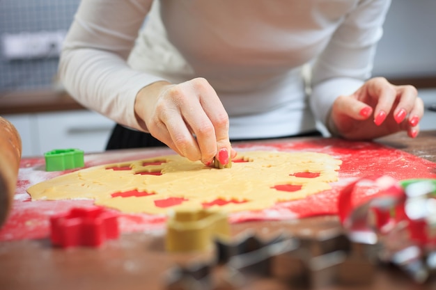 Les jeunes mains coupant la pâte de gingembre à la cuisine moderne