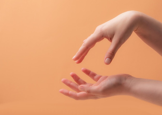 Jeunes mains féminines appliquant de la crème ou de la lotion