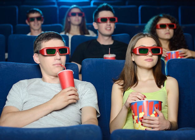 Les jeunes mangent du pop-corn et boivent du soda.