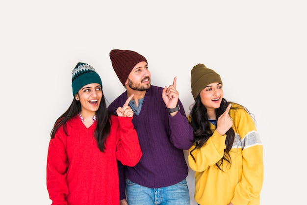 Jeunes mannequins ou amis indiens asiatiques posant tout en portant un pull et des chapeaux en laine colorés