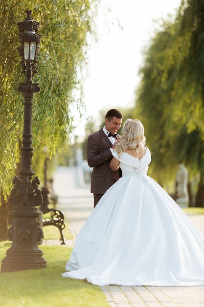 Photo jeunes mariés au jour du mariage en marchant à l'extérieur sur la nature du printemps. couple nuptiale