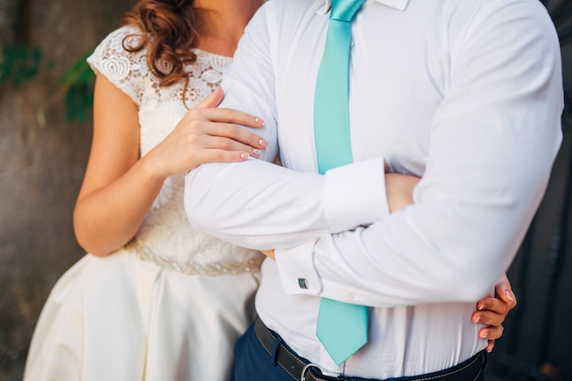 Jeunes mariés au jour du mariage marchant à l'extérieur sur la nature printanière