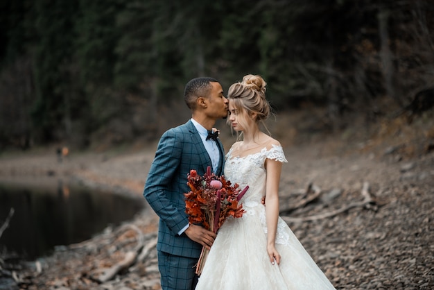 Jeunes mariés à la cérémonie de mariage sur le magnifique lac.