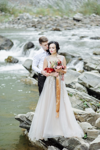 Jeunes mariés. Cérémonie de mariage près d'une rivière de montagne