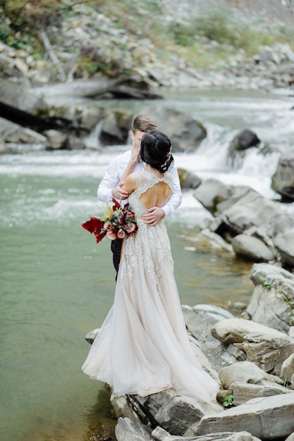 Jeunes mariés. Cérémonie de mariage près d'une rivière de montagne