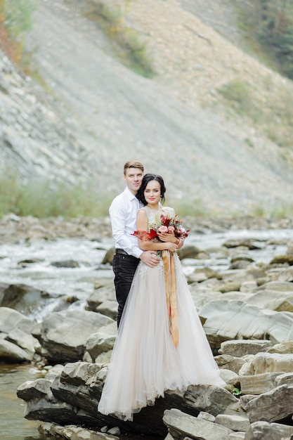 Jeunes mariés. Cérémonie de mariage près d'une rivière de montagne