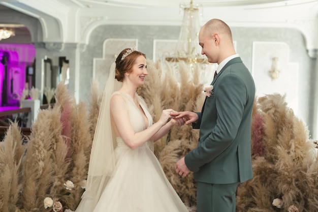 Les jeunes mariés échangent des alliances lors de leur belle cérémonie de mariage