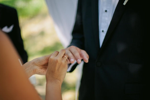 Les jeunes mariés échangent des alliances, près de l'arche de mariage, lors de la cérémonie de mariage. mariage. mise au point douce