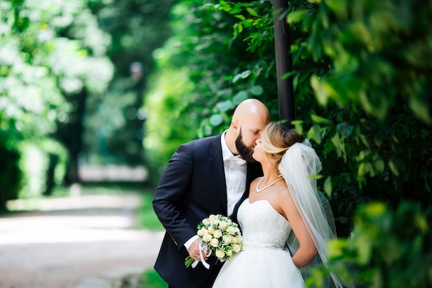 Jeunes mariés européens s'embrassant dans le parc