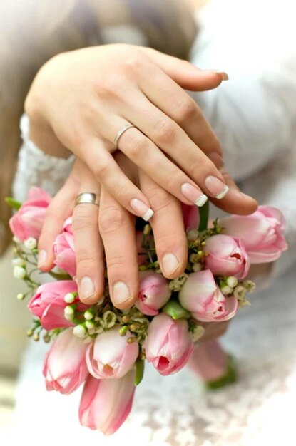 Les jeunes mariés gardent les mains sur le bouquet.