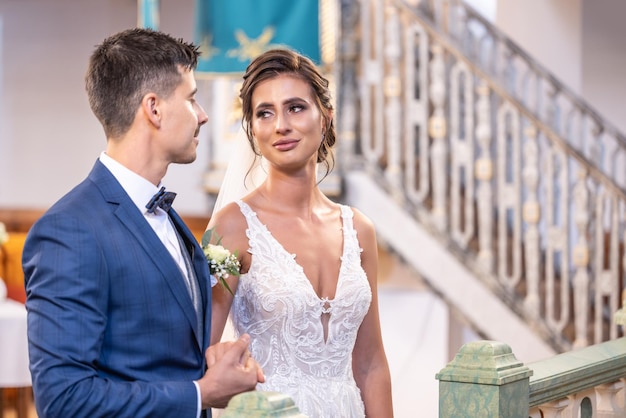 Les jeunes mariés heureux se regardent dans les yeux après avoir dit ce que je fais au mariage