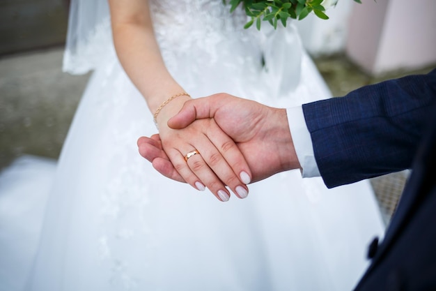 Les jeunes mariés le jour du mariage, les mariés se tenant la main, les mariés