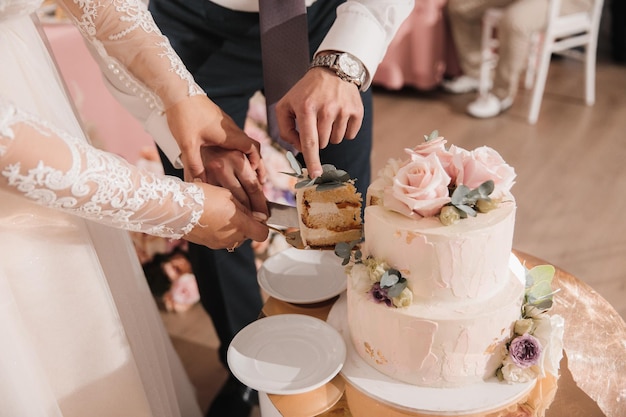 Les jeunes mariés ont coupé le premier morceau de gâteau de mariage à leur mariage