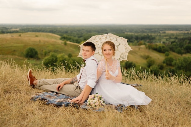 Les jeunes mariés en pique-nique dans la nature. Jeunes mariés après la cérémonie de mariage.