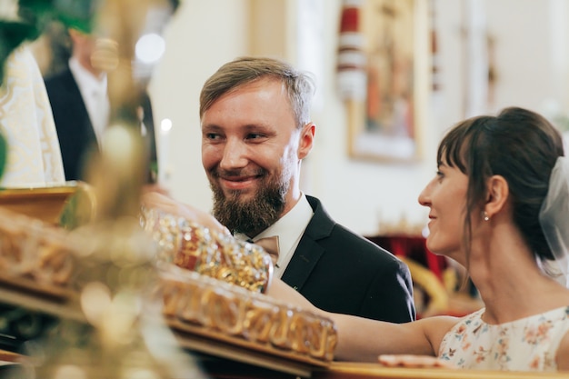 Les jeunes mariés prêtent serment devant Dieu dans l'église