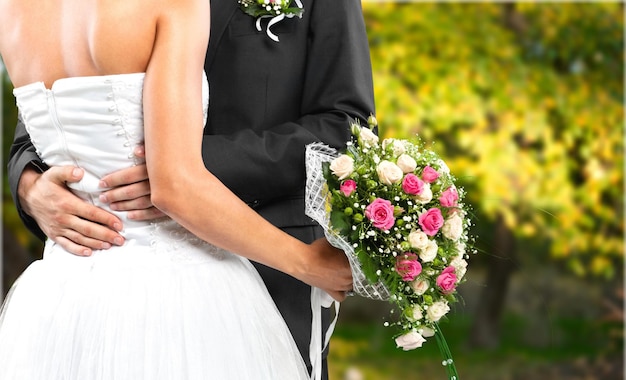 Jeunes mariés tenant un bouquet élégant pendant la cérémonie de mariage