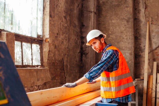 Les jeunes ouvriers découpent des planches à l'usine de bois