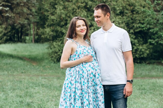 Jeunes parents dans le parc par une chaude journée de printemps