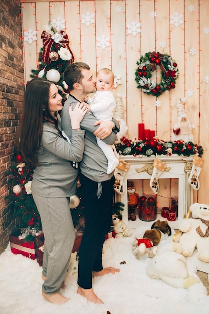 Jeunes parents avec jeune fils près de l'arbre de Noël