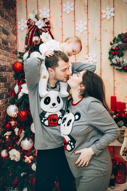 Jeunes parents avec jeune fils près de l'arbre de Noël