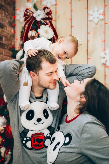 Jeunes parents avec jeune fils près de l'arbre de Noël