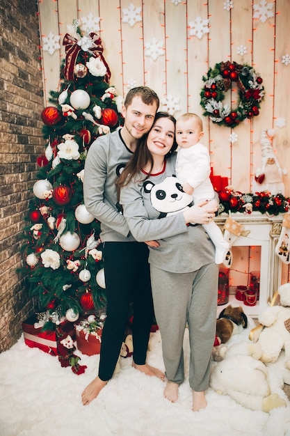 Jeunes parents avec jeune fils près de l'arbre de Noël