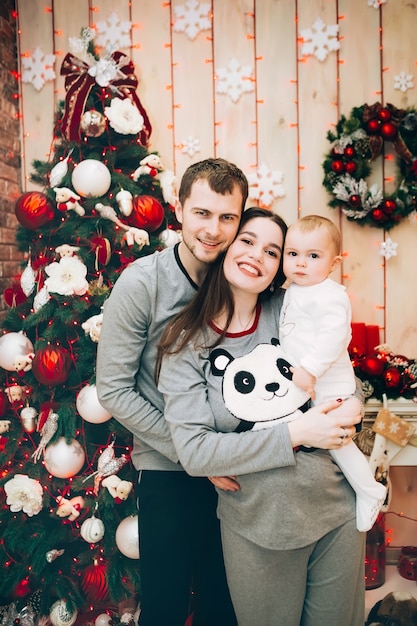 Jeunes parents avec jeune fils près de l'arbre de Noël