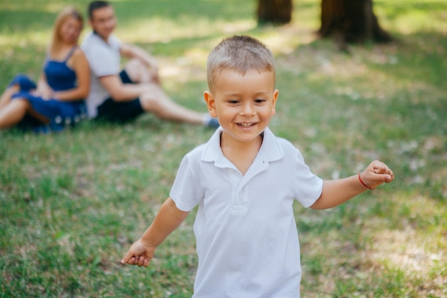 Les jeunes parents jouent dans le parc avec leur fils