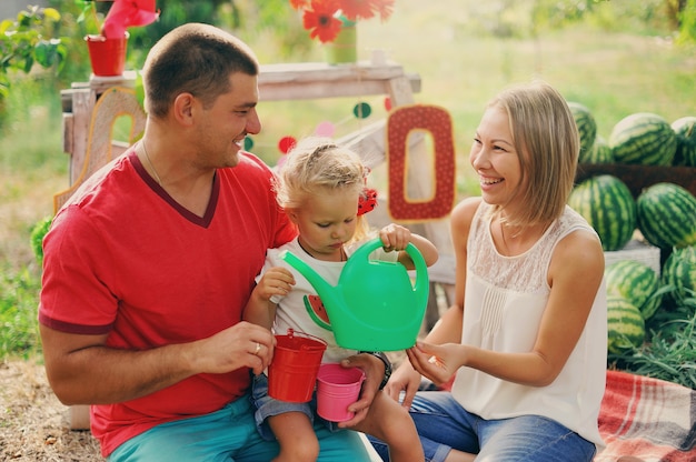 Les jeunes parents jouent avec un petit enfant dans le jardin