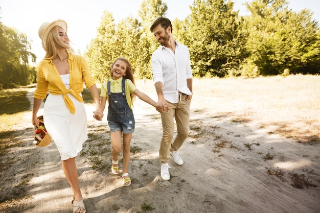 Jeunes parents marchant avec un enfant dans la nature