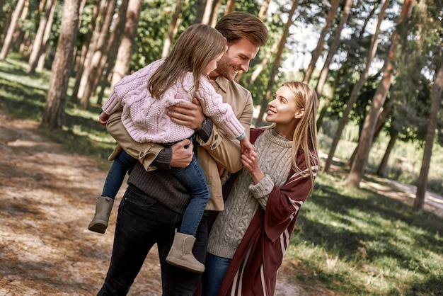 Jeunes parents avec petite fille dans la forêt d'automne