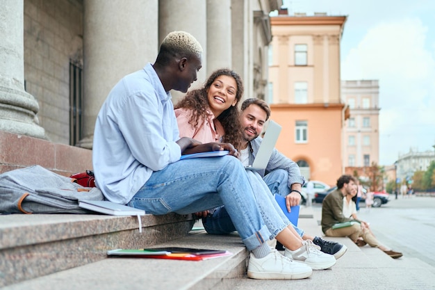 Les jeunes partagent les nouvelles assis sur les marches