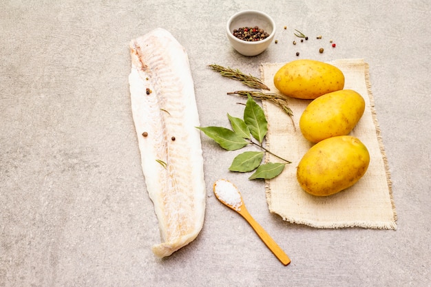 Jeunes pommes de terre crues et filets de merlu surgelés aux herbes et épices