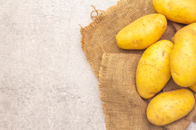 Jeunes pommes de terre crues non pelées sur un sac