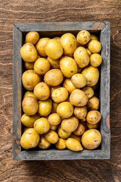 Photo les jeunes pommes de terre dans une boîte en bois.